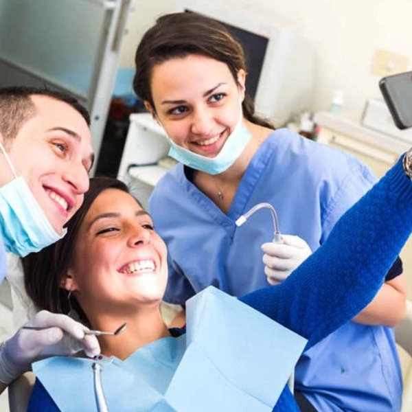 Seguro Dental - Paciente alegre realizándose una foto en gabinete