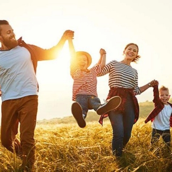 Seguro de Vida - Familia de 4 miembros saltado por la pradera